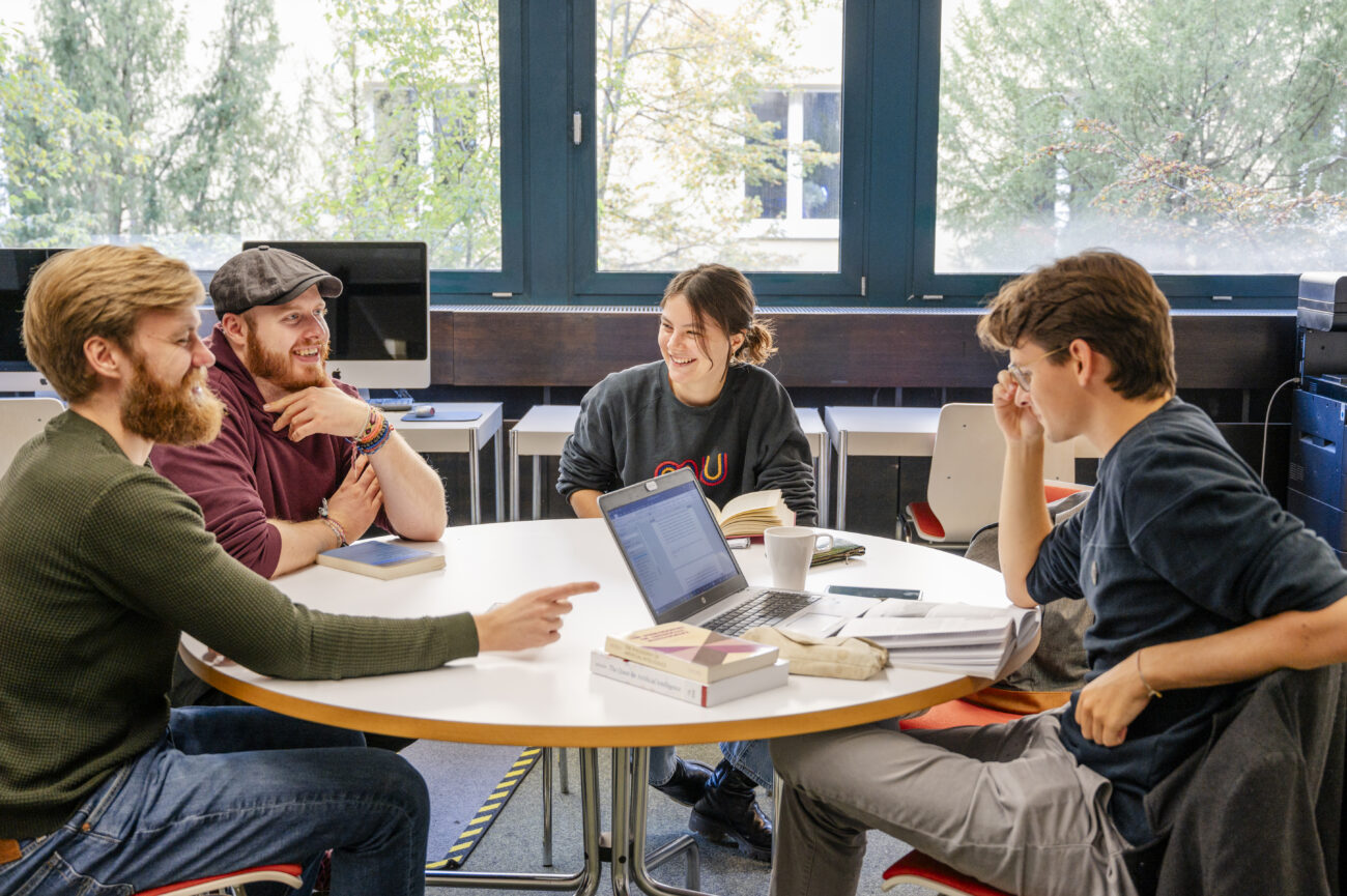 Studierende der TUM sitzen in HFPH zusammen und diskutieren über philosophische Frage