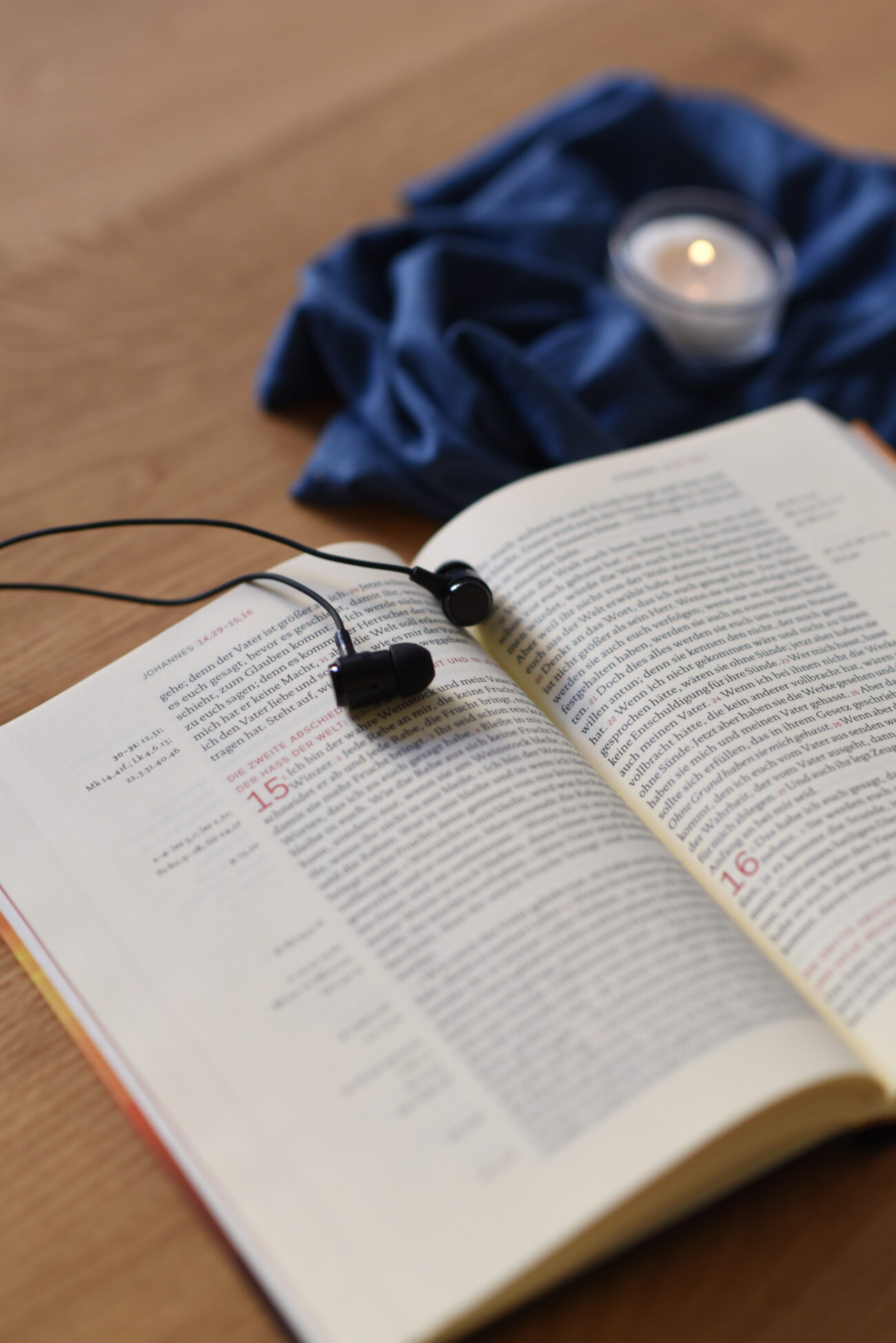 Symbolbild Bibel Kopfhörer und Kerze