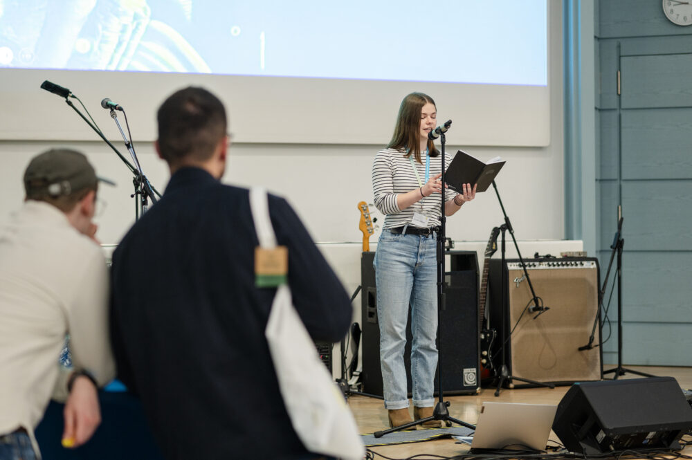 Nika auf der Bühne in der Aula beim Vortragen ihres Beitrags im Rahmen des Poetry Slams